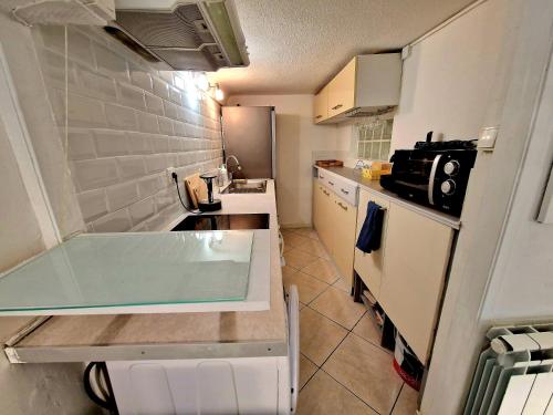 a small kitchen with a sink and a counter top at Le Cosy - Place Masséna in Nice