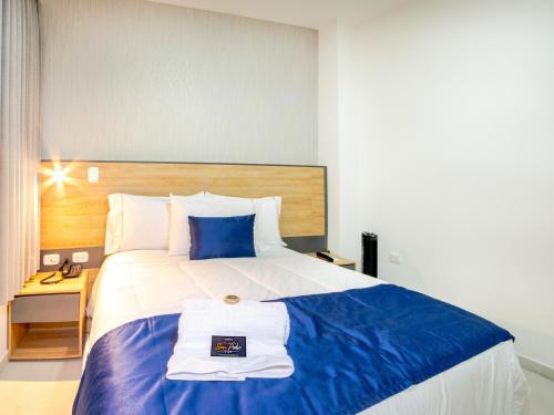 a hotel room with a large bed with a towel on it at HOTEL SAN PEDRO PITALITO in Pitalito