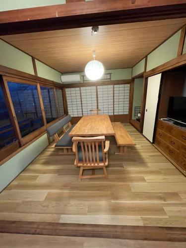 a large room with a table and chairs and windows at えん吉野絶景広がる隠れ家1棟貸切ペットokサウナ室完備 in Yoshino