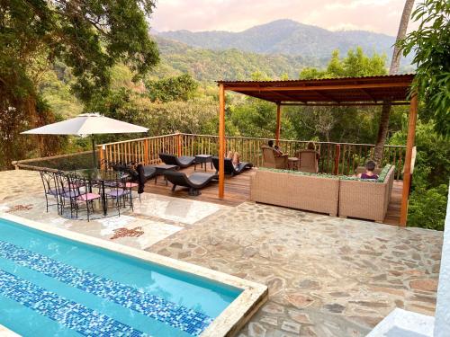 a patio with a pool and a table and chairs at Hotel Minca - La Casona in Minca