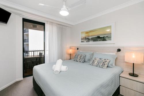 a bedroom with a white bed with a white chair at Calypso Plaza Resort Unit 306 in Gold Coast