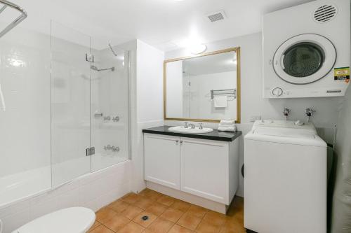 a white bathroom with a sink and a shower at Calypso Plaza Resort Unit 306 in Gold Coast