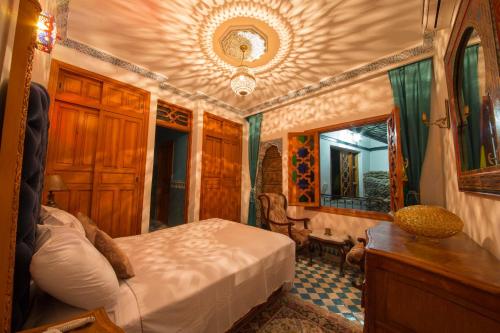 1 dormitorio con cama y espejo en Riad Scalia Traditional Guesthouse Fes Morocco, en Fez