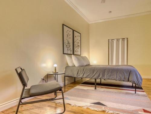 a bedroom with a bed and a chair at Twin Cedars Getaway - Meredith Lodging in Welches