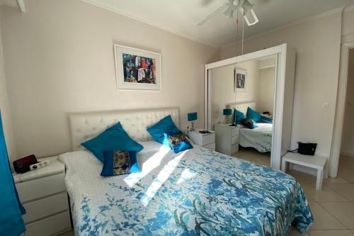 um quarto com uma cama com lençóis azuis e um espelho em 2 rooms facing south 300m from the Croisette LIVE IN LE BOSQUET em Cannes