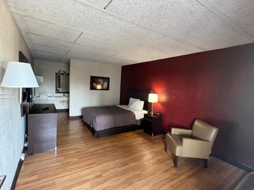 a hotel room with a bed and a chair at Knights Inn Ashland in Ashland