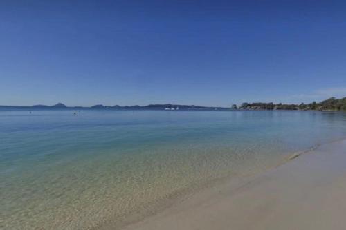 a view of a beach with the sand and water at Coastal Paradise at Fore Dek 3, 17 Soldiers Point Road - water views, linen, Wi-Fi, Air Con in Soldiers Point