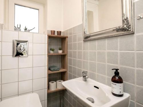Baño blanco con lavabo y espejo en Holiday home Hurup Thy XVIII, en Sønder Ydby