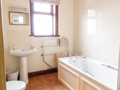ein Badezimmer mit Badewanne, Waschbecken und Toilette in der Unterkunft Courtyard Cottage in Duns