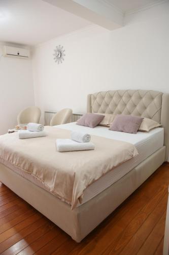 a large white bed with two towels on it at Apartman Pegasus in Vrnjačka Banja