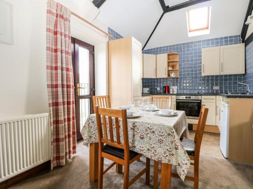 a dining room with a table and chairs in a kitchen at The Granary in Henfield