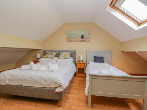 1 dormitorio en el ático con 2 camas y tragaluz en Braeside, en Coniston