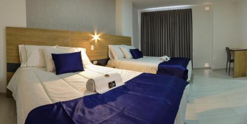 a hotel room with two beds with blue and white at HOTEL SAN PEDRO PITALITO in Pitalito
