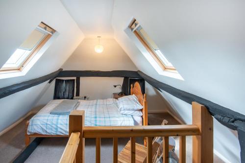 Schlafzimmer im Dachgeschoss mit einem Bett und Oberlichtern in der Unterkunft Woodbine Cottage in Market Rasen