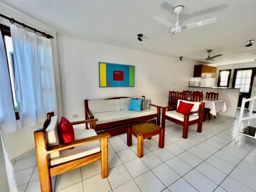 ein Wohnzimmer mit einer Couch und einem Tisch und Stühlen in der Unterkunft Duplex Aconchegante Residencial Mont Sinai in Porto Seguro