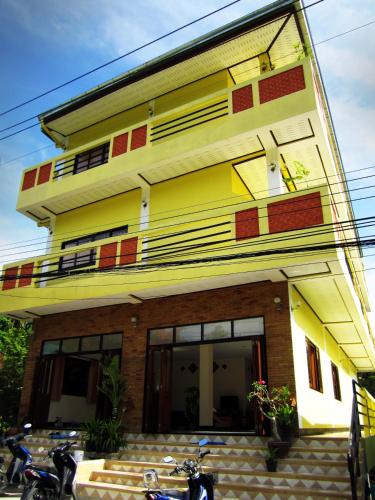 un edificio amarillo con motocicletas estacionadas frente a él en Big Yellow House en Ko Tao