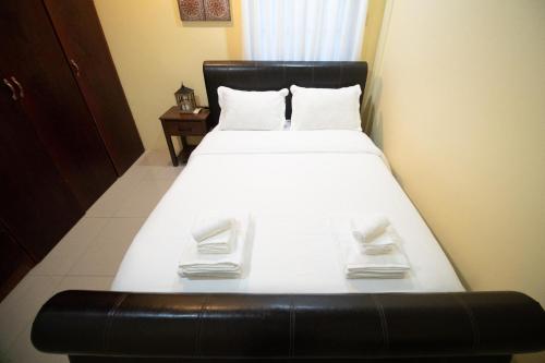 1 dormitorio con 1 cama grande y cabecero negro en Stacys Place #1 2 Bedroom Apartment en Puerto España