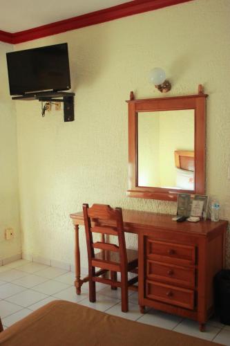 um quarto com uma secretária, um espelho e uma cadeira em Hotel Pacific em Tecomán