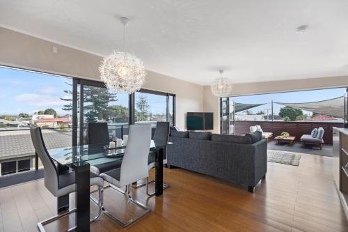 a dining room and living room with a dining table at Maranui BeachSide Retreat - Mt Maunganui Home in Mount Maunganui