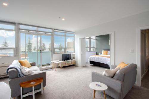 Coastal Crib - Napier Holiday Apartment في نابيير: غرفة معيشة مع غرفة نوم وسرير