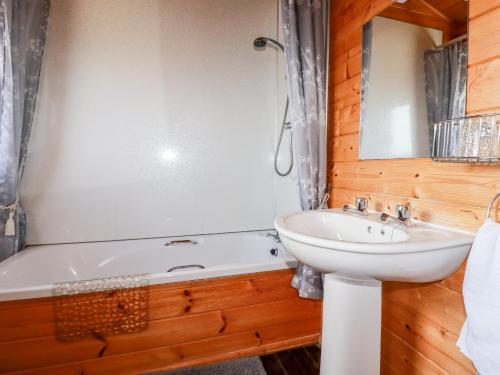 a bathroom with a sink and a bath tub and a sink at Hazel Lodge in Bodmin