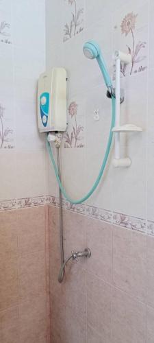 a shower in a bathroom with a blue hose at Big Yellow House in Ko Tao