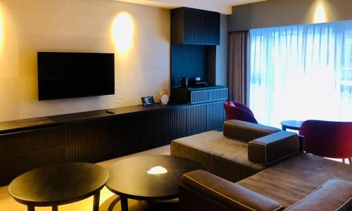 a hotel room with a couch and a tv at Shogetsu Grand Hotel in Jozankei