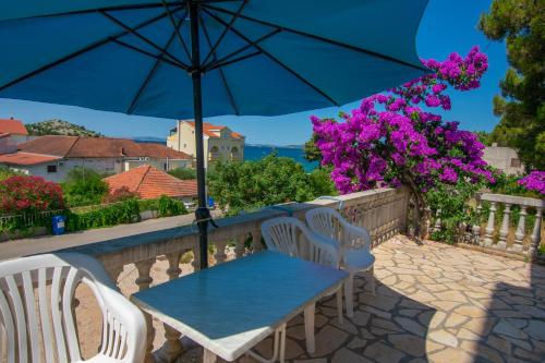 a table and chairs with an umbrella on a patio at Apartments Calida A in Drage
