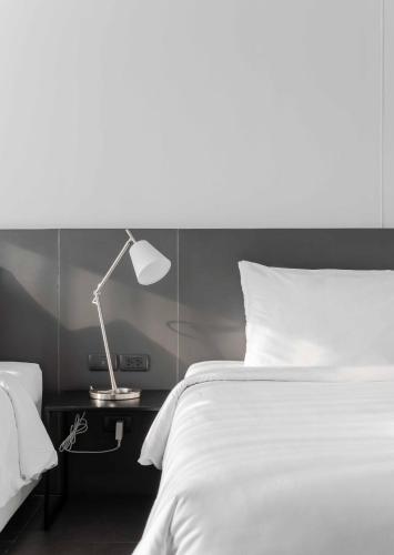 a bedroom with a bed and a lamp on a table at POR Thapae Gate in Chiang Mai
