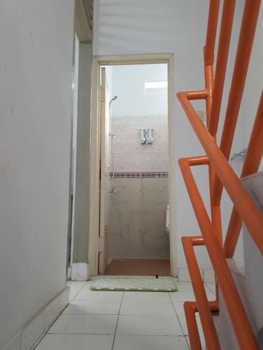 ein Bad mit einer ebenerdigen Dusche und einem Eingang in der Unterkunft C4 homestay in Jakarta