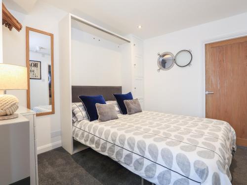 ソルカムにある35 The Salcombeのベッドルーム(青い枕と鏡付きのベッド1台付)