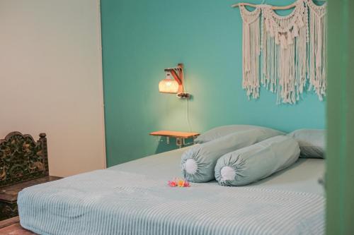 1 cama con 2 almohadas y pared azul en Abrakadabra 747, en Timuran