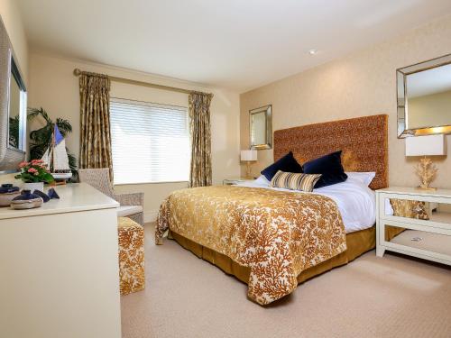 Un dormitorio con una cama grande y un espejo. en Quayside, Dart Marina, en Dartmouth