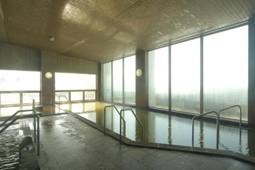 豐浦町的住宿－Spa SHIOSAI，一座有窗户的建筑中的空游泳池