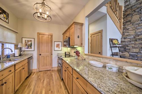 uma grande cozinha com armários de madeira e uma parede de pedra em Beautiful Lake Glenville Townhome with Mountain View em Cashiers