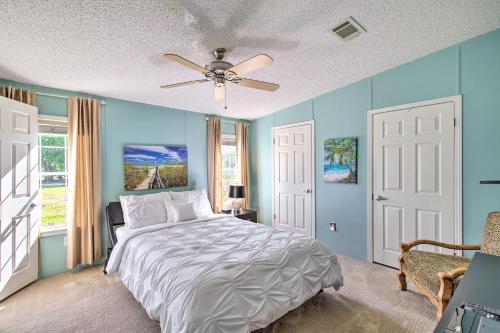 um quarto azul com uma cama e uma ventoinha de tecto em Coastal Florida Cottage with Screened-In Porch! em Sebastian