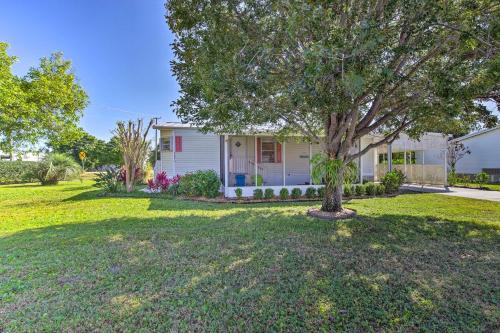 a house with a tree in a yard at Sebastien Cottage with Screened Porch, 5 Mi to Beach in Sebastian