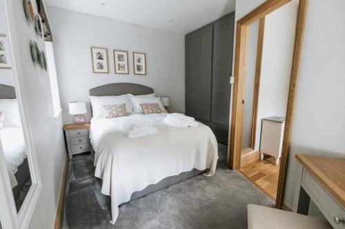 - une chambre avec un lit blanc et un miroir dans l'établissement GABLE COTTAGE - One Bed Cottage Close to Holmfirth and the Peak District, à Hepworth