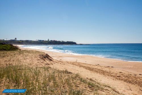 a sandy beach with the ocean in the background at Golden Sands Pet Friendly 2 Mins Walk to Beach in Culburra Beach