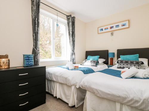 two beds in a bedroom with a window at Valley Lodge 52 in Callington
