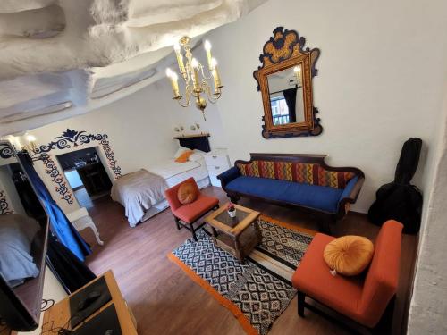 a living room with a bed and a couch and a mirror at Anqas Apartment Cusco in Cusco