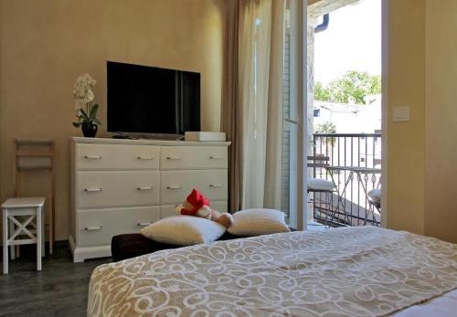 een slaapkamer met een bed en een dressoir met een televisie bij Holiday house Berna 2- with pool in Malinska