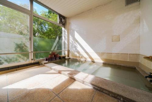 an empty room with a large window and a pool at Trip7箱根仙石原温泉ホテル in Sengokuhara
