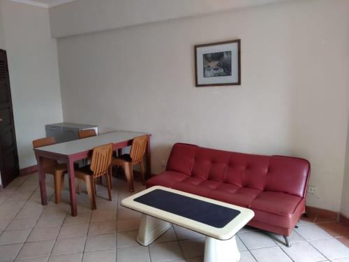 a living room with a red couch and a table at New Renovated 2 Rooms Luxury Suites Anyer in Anyer