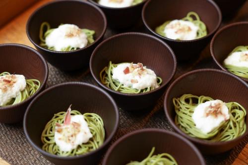 a group of small black cups filled with food at HOTEL MYSTAYS Kyoto Shijo in Kyoto