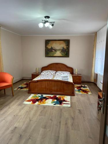 a bedroom with a bed and a rug on the floor at Casa Titiana Suncuius in Şuncuiuş