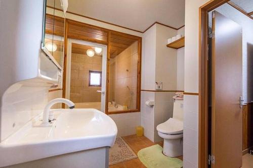 a white bathroom with a sink and a toilet at Midori House - walking distance to Rusutsu Resort in Rusutsu