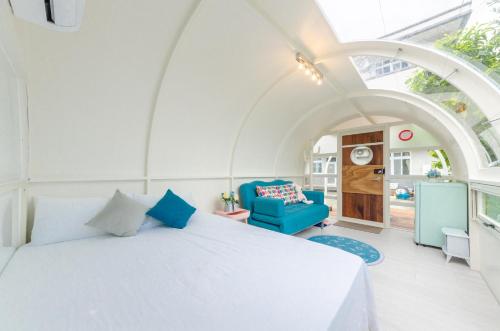 ein Schlafzimmer mit einem weißen Bett und einem blauen Sofa in der Unterkunft Long Forest Homestay in Luodong