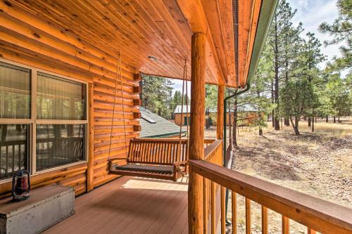 a porch of a log cabin with a bench on it at Family Game Room Spacious Overgaard Cabin in Overgaard