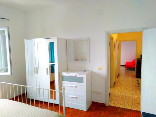 a bedroom with a white cabinet and a hallway at Ghiaie sea view in Portoferraio